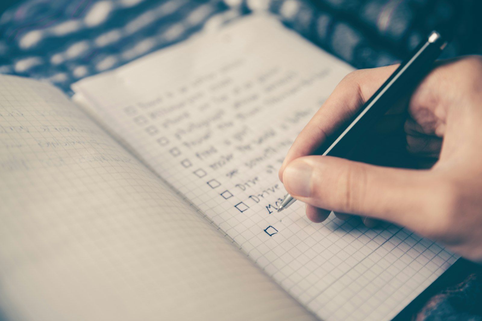 Someone writing a list in a notebook.