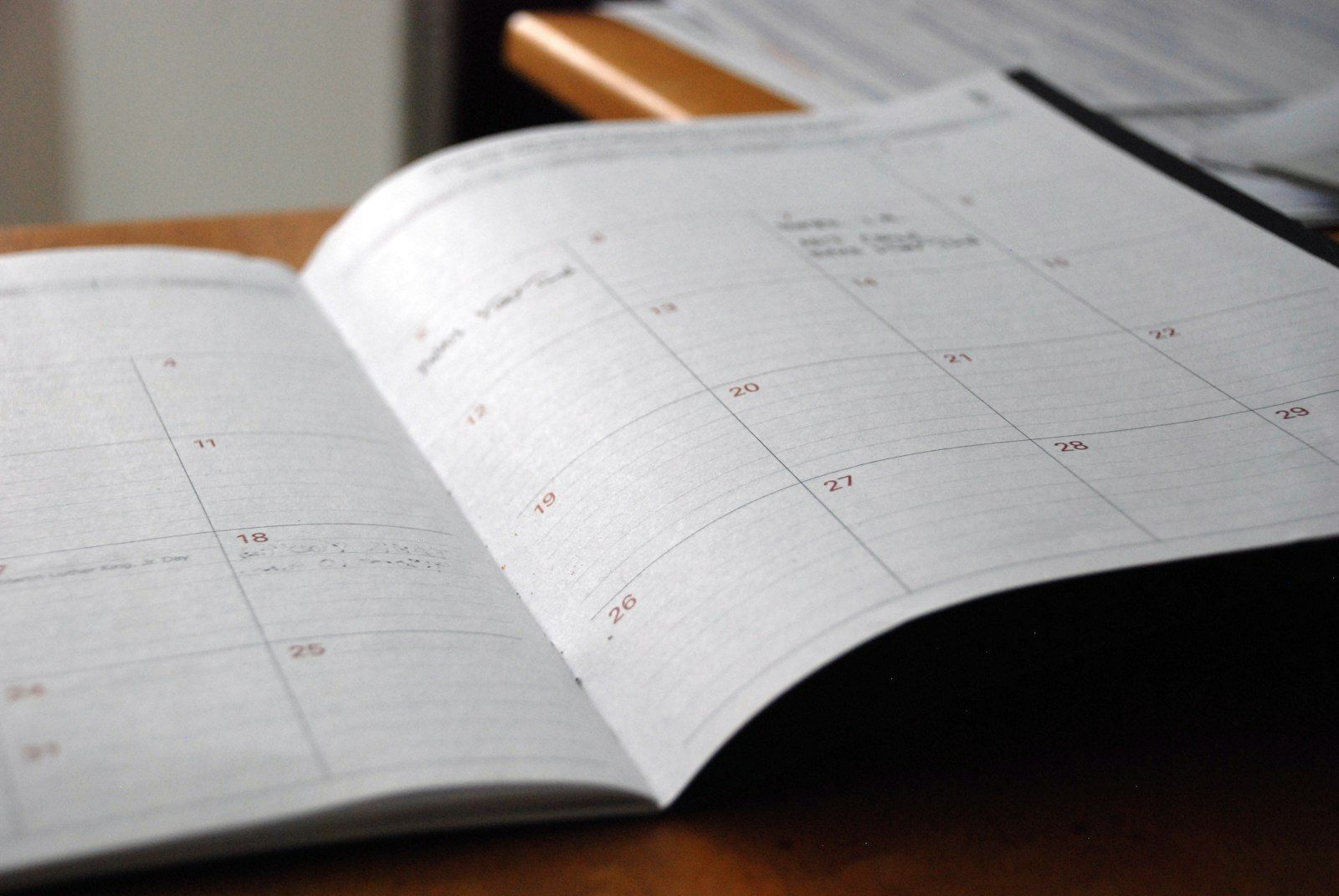 An open monthly planner on a wooden desk.