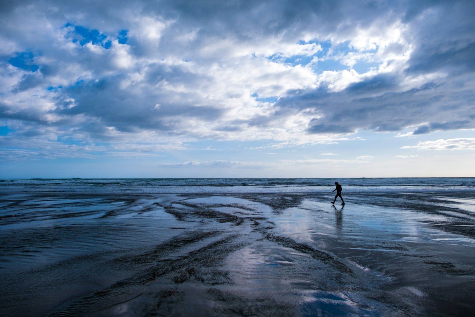 A person walking alone on a beach.