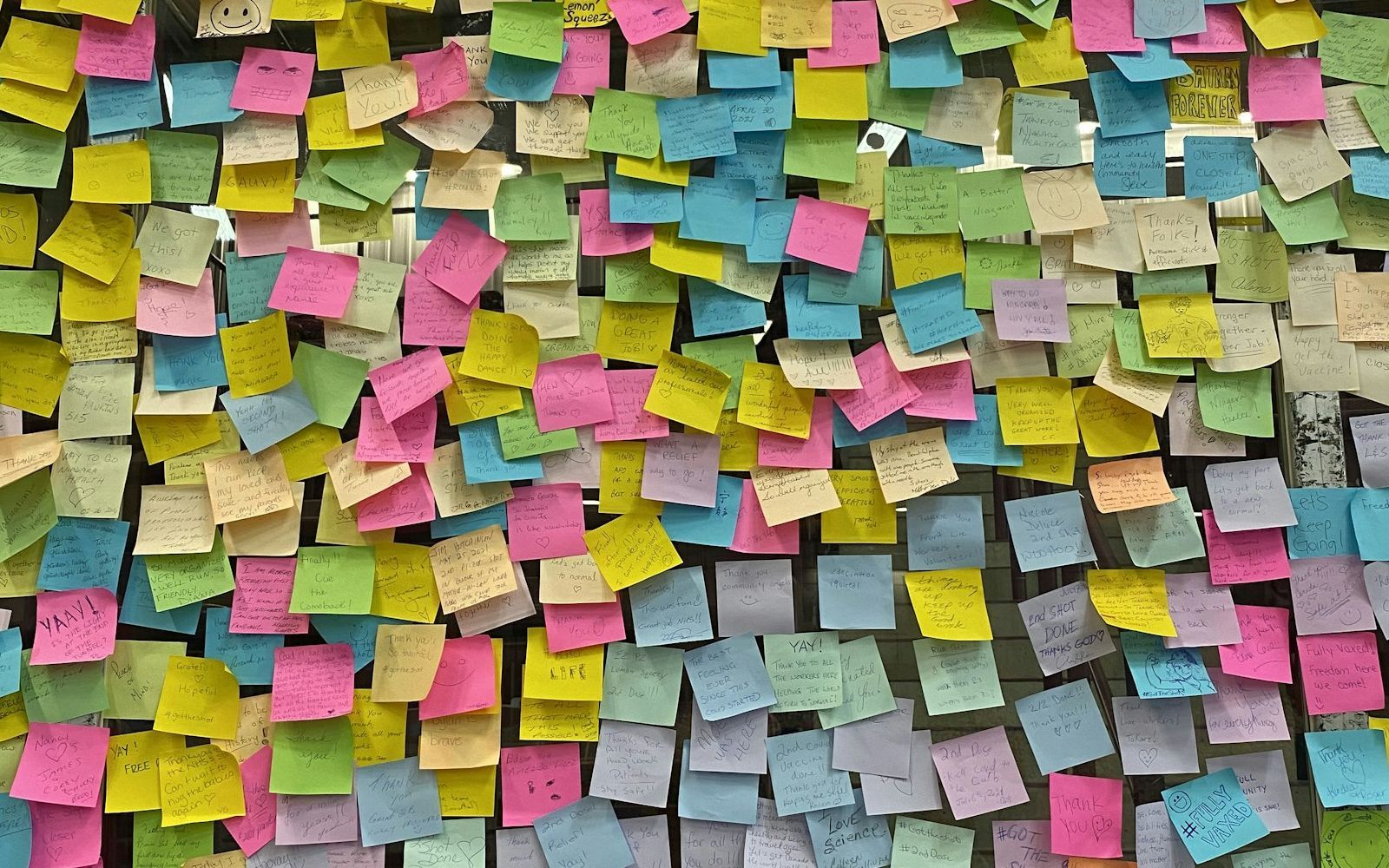 A wall covered in sticky notes.